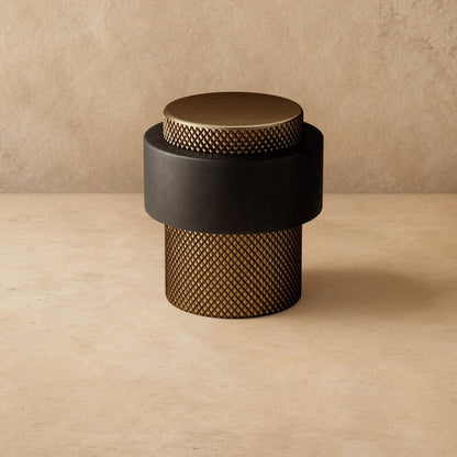 Residence Supply Finio door stop mounted on a wall, made of durable metal for preventing door damage in home and garden settings.