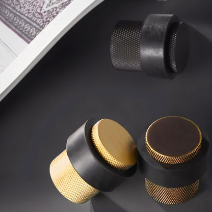 Residence Supply Finio door stop on a hardwood floor, designed to prevent door movement and protect walls.