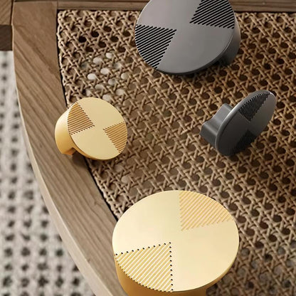 Close-up of Residence Supply Flict geometric cabinet knob on cane furniture, showcasing modern hardware design.