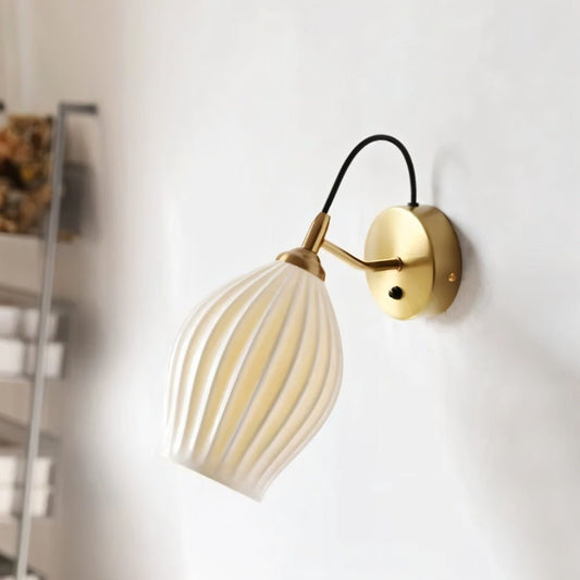 Modern Haela Wall Lamp by Residence Supply, featuring a sleek design with a curved metallic arm and a round lampshade.
