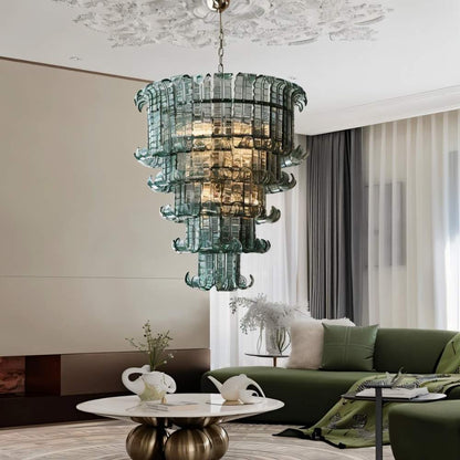 Tiered glass Halan Chandelier by Residence Supply hanging in a living room with elegant lighting and modern decor.