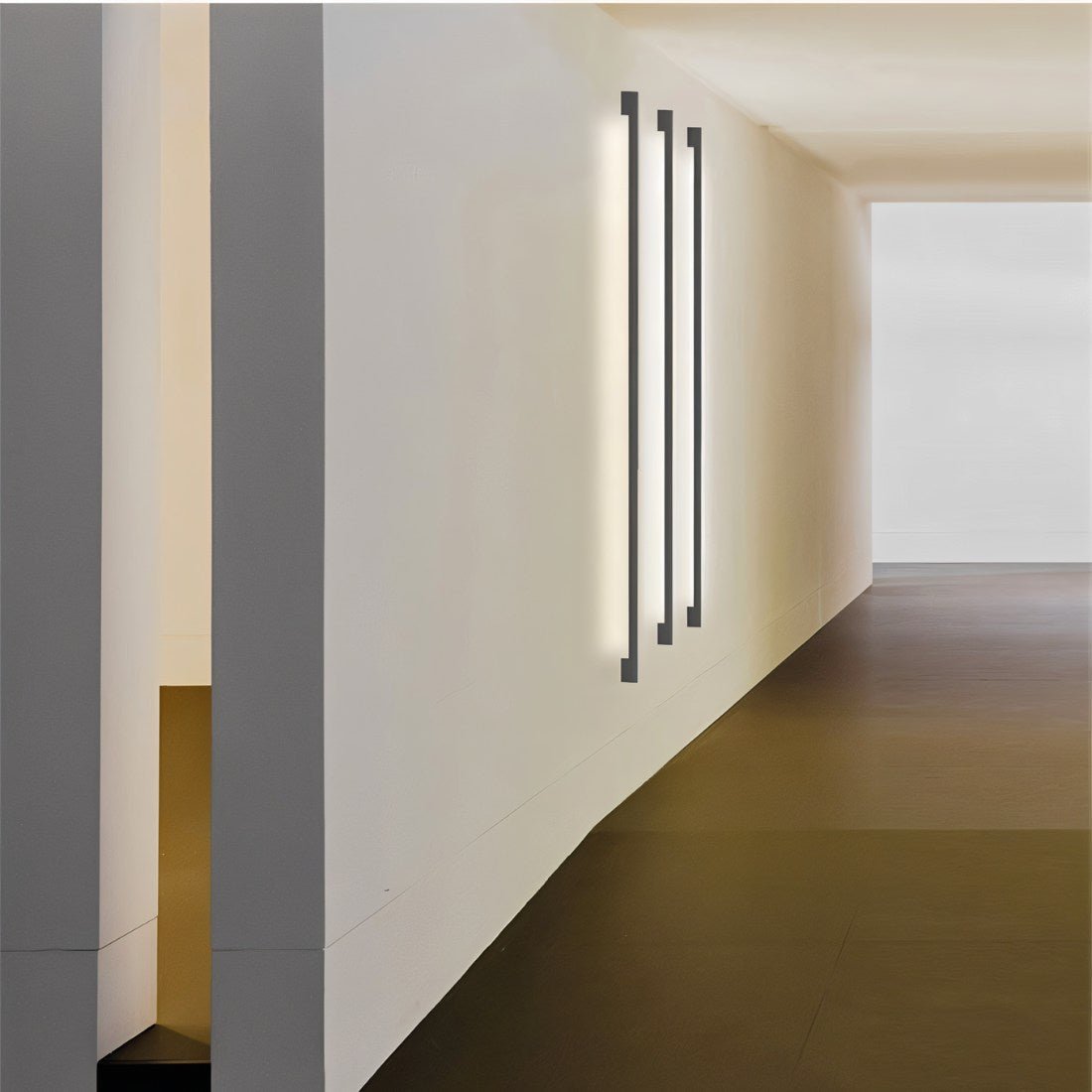 Hanur Wall Lamp by Residence Supply mounted on a wall with a sleek, modern design and a warm light glow.