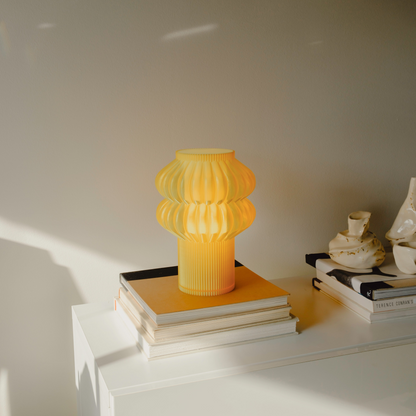 Terrarium Labs Oppi Table Lamp with honey-colored glass shade and modern design, perfect for cozy living spaces.