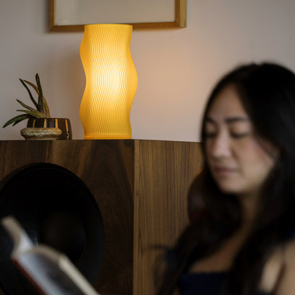 Terra Labs Woogie Table Lamp with a warm honey-colored ceramic base and a simple fabric shade, ideal for modern decor.