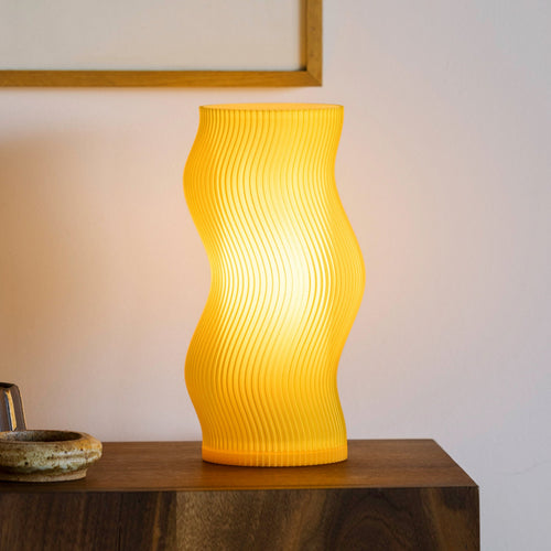 Terra Labs Woogie Table Lamp with a honey-colored ceramic base and a white fabric shade, stylish home lighting.