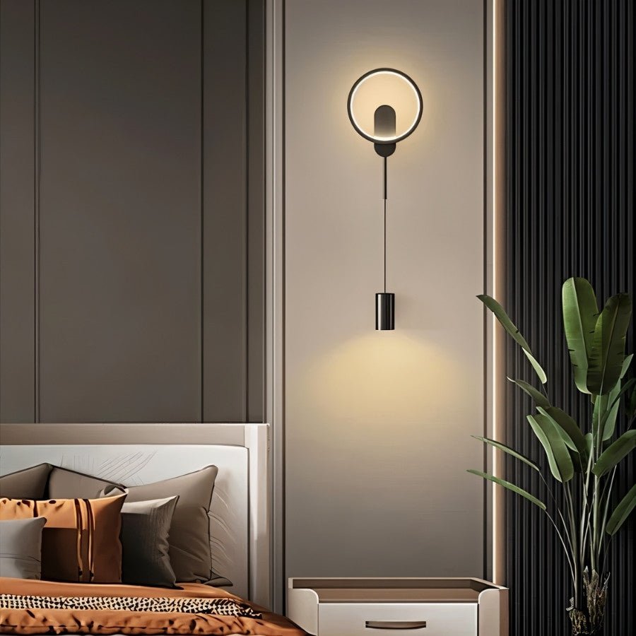 Black Imrat Wall Lamp by Residence Supply mounted on a bedroom wall, featuring a modern design for ambient lighting.