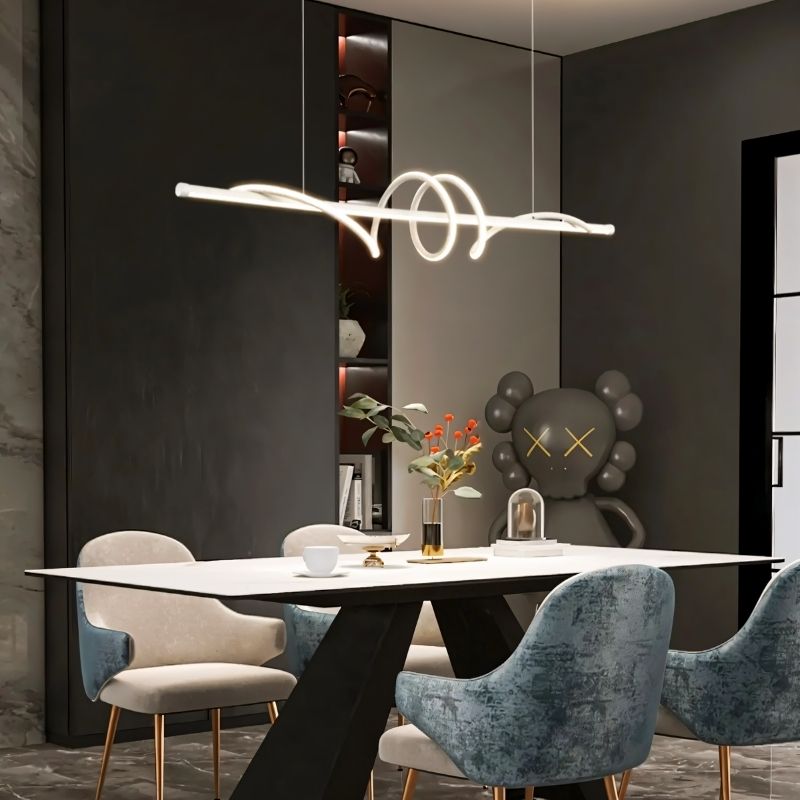 Lumexis pendant light hanging in a dining room with a modern design, featuring sleek metal and glass elements.