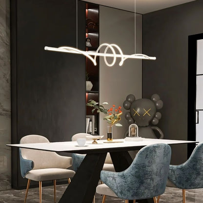 Lumexis pendant light hanging in a dining room with a modern design, featuring sleek metal and glass elements.