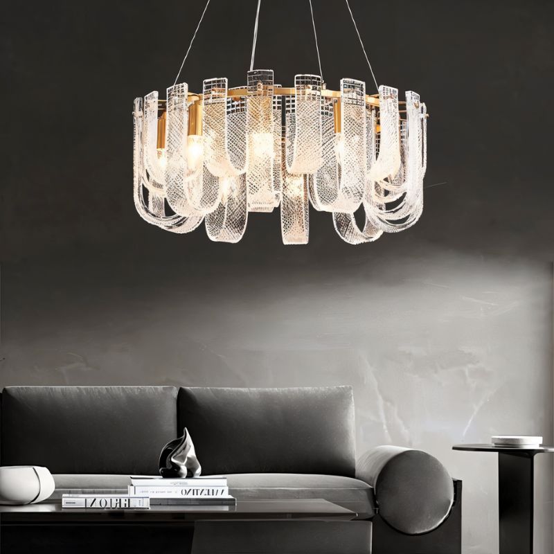 Round Mudil chandelier by Residence Supply with intricate metal design, hanging from a ceiling light fixture in a modern interior.