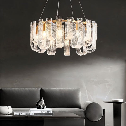 Round Mudil chandelier by Residence Supply with intricate metal design, hanging from a ceiling light fixture in a modern interior.