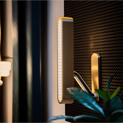 Modern Munira Wall Lamp from Residence Supply, showcasing a sleek design with a curved arm and elegant light fixture.