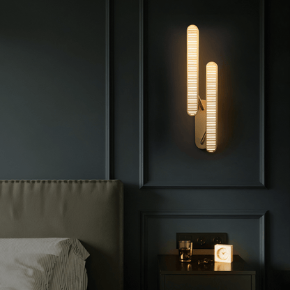 Munira wall lamp by Residence Supply featuring a sleek design with a curved metal arm and a cylindrical shade for modern lighting.