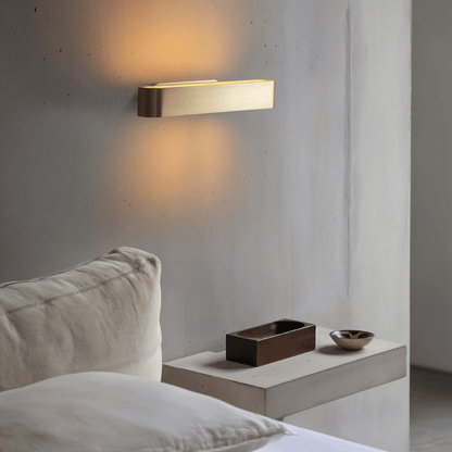 Modern Munira Wall Lamp by Residence Supply with a sleek design, mounted on a wall with warm ambient lighting.