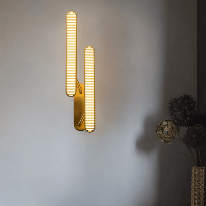 Modern Munira Wall Lamp by Residence Supply with sleek design and warm lighting, mounted on a wall in a contemporary setting.