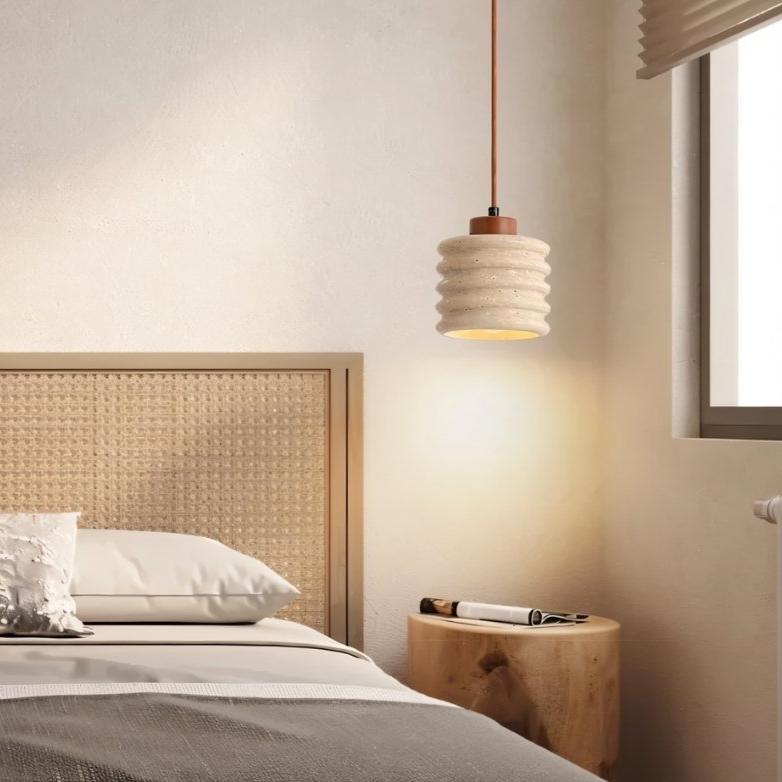 Nexon pendant light by Residence Supply hanging in a bedroom, featuring a travertine finish and modern design.