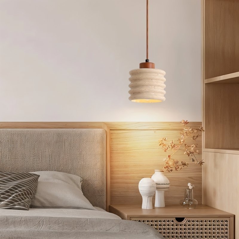 Nexon pendant light by Residence Supply with a travertine finish, hanging in a modern bedroom setting.
