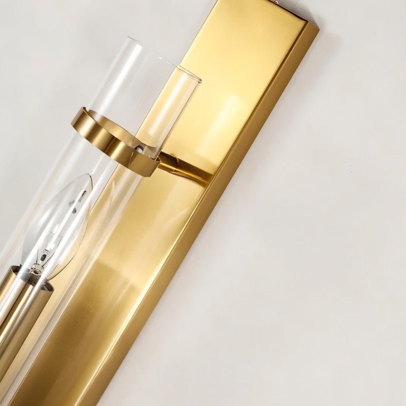 Close-up of Nexovia Wall Lamp by Residence Supply featuring a brass body and glass shade for stylish interior lighting.