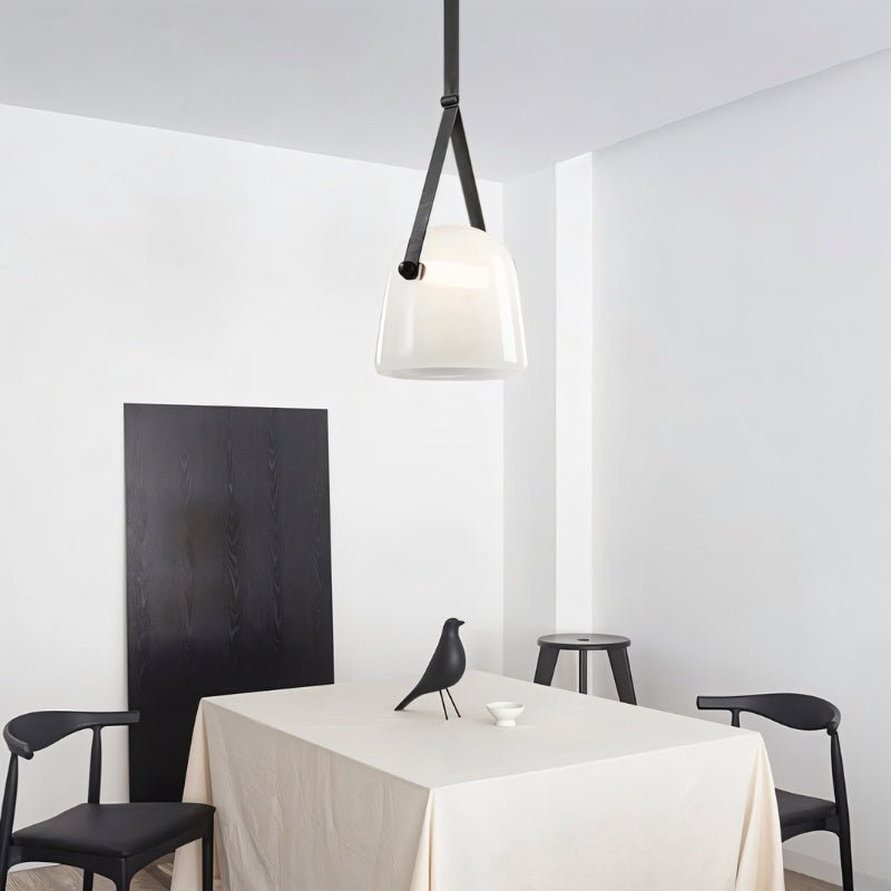 Modern Nola Pendant Light by Residence Supply with sleek metal finish and clear glass shade, hanging from a ceiling.