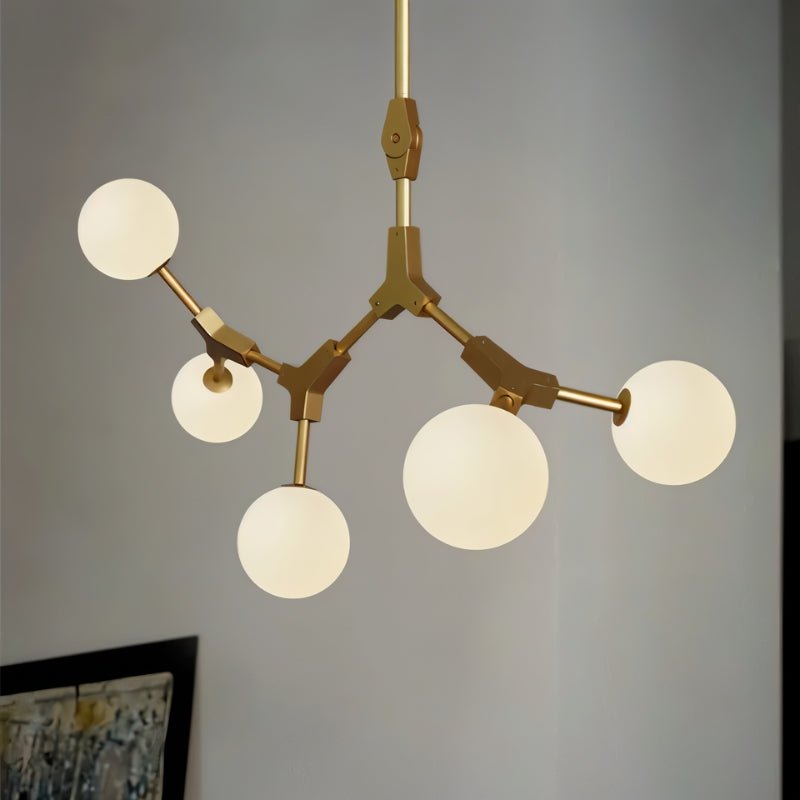 Elegant Noxira chandelier by Residence Supply featuring multiple glass globes and a sleek brass finish.