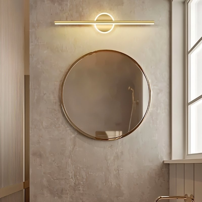 Modern gold Nyxtra Wall Lamp by Residence Supply, mounted above a bathroom vanity with sleek, contemporary design.