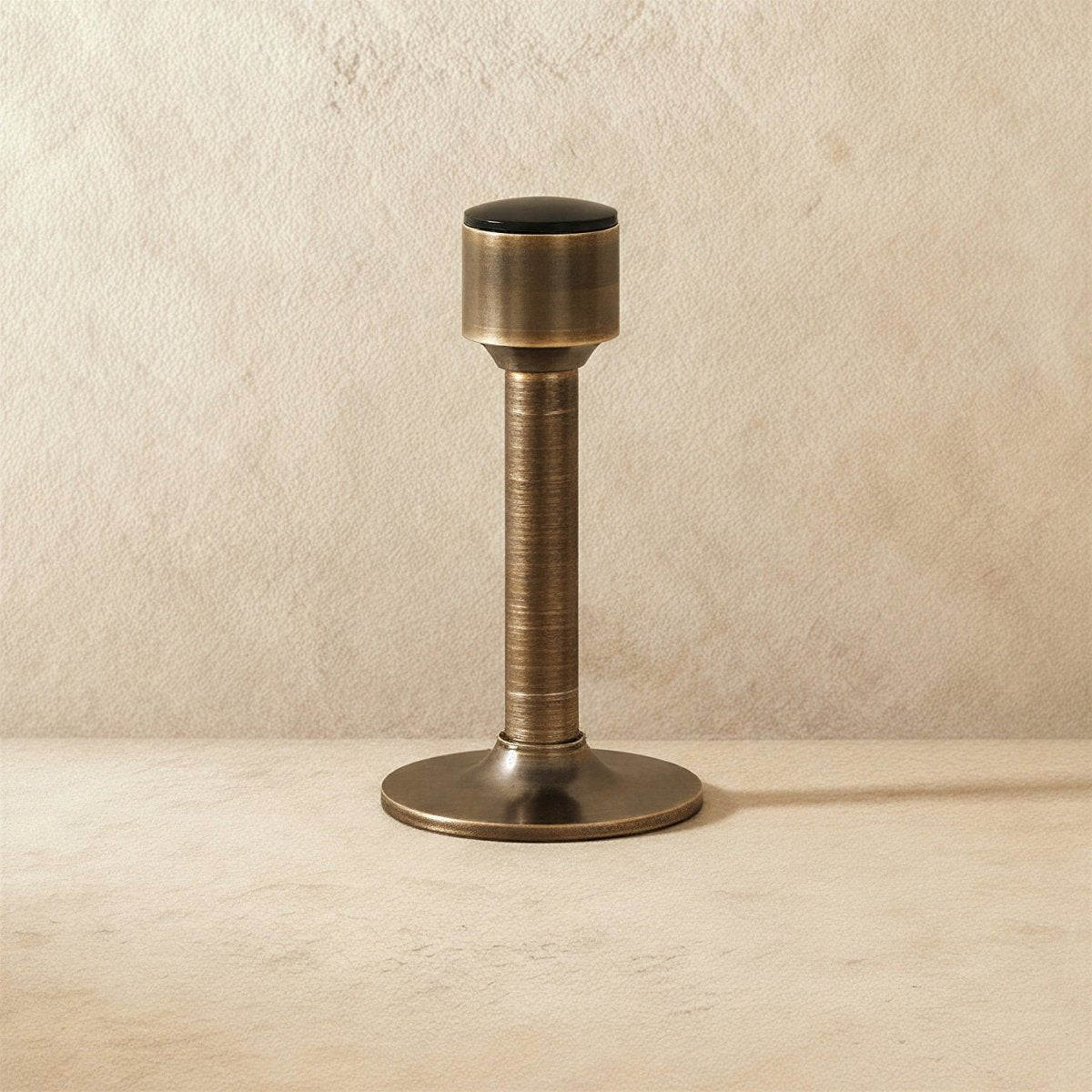 Open-box Residence Supply Pesu door stop mounted on a wall, designed to prevent door damage and keep doors open in home and garden.