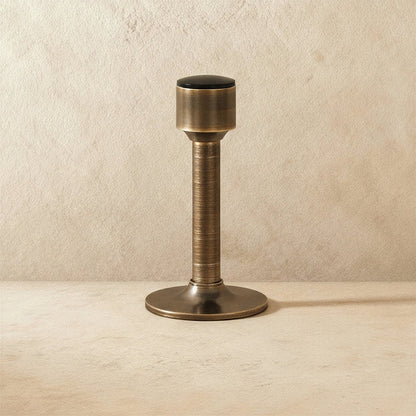 Open-box Residence Supply Pesu door stop mounted on a wall, designed to prevent door damage and keep doors open in home and garden.