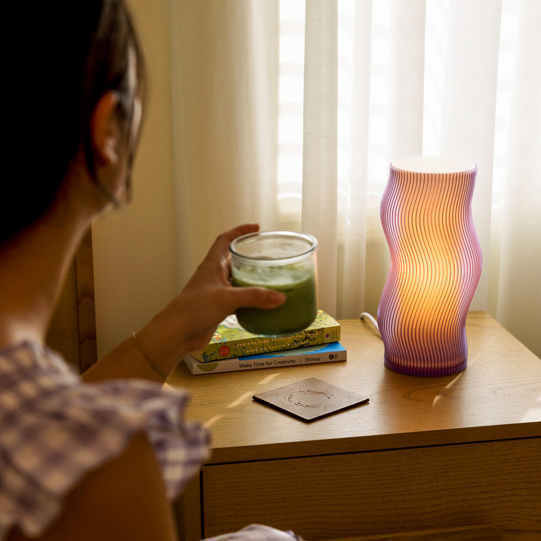 Purple Terra Labs Woogie Table Lamp with a modern, whimsical design on a wooden surface.