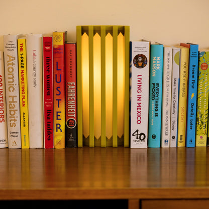 Terra Labs radiator-inspired mustard yellow table lamp with sleek design and adjustable arm on a wooden side table.