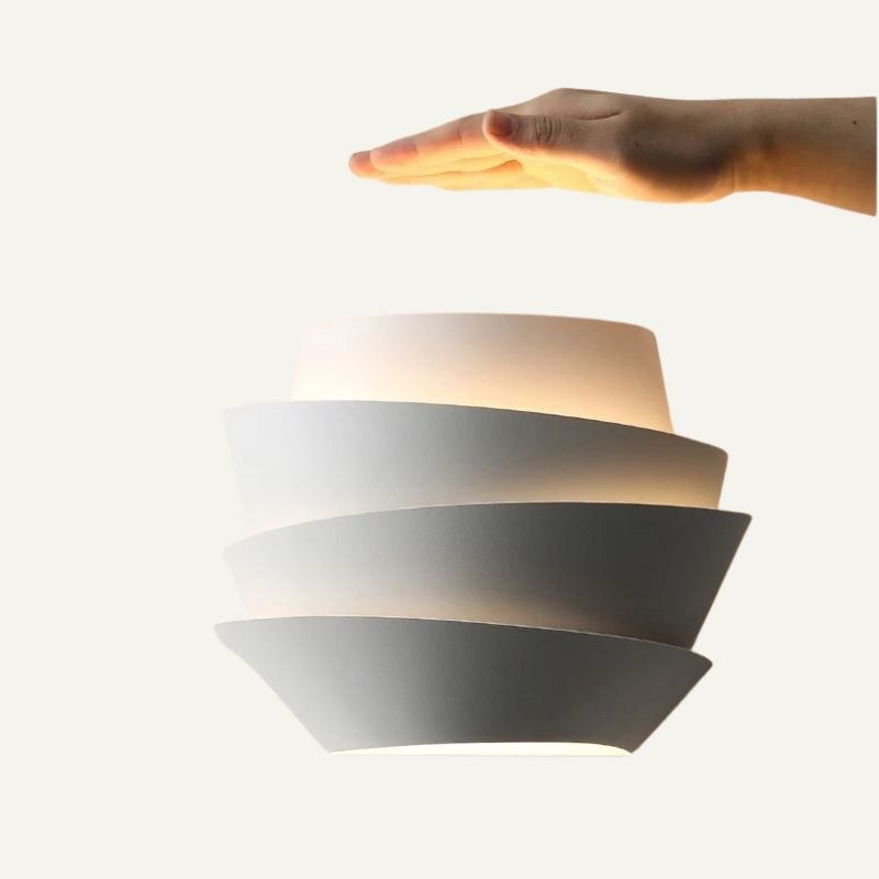 Residence Supply Rigno Wall Lamp with sleek metal finish and modern design, mounted on a wall in a stylish interior setting.