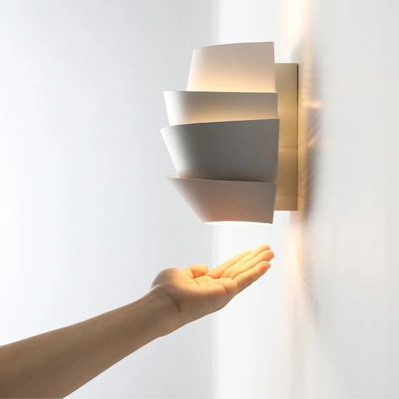 Rigno Wall Lamp by Residence Supply mounted on a wall, featuring a sleek modern design with a cylindrical light fixture.