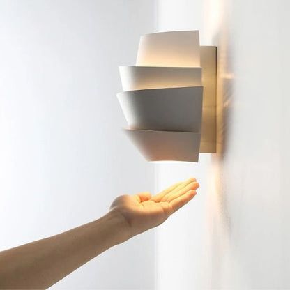 Rigno Wall Lamp by Residence Supply mounted on a wall, featuring a sleek modern design with a cylindrical light fixture.