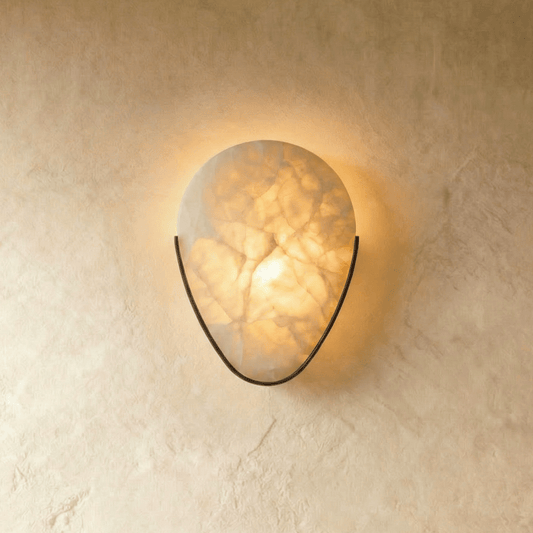 Alabaster wall sconce by Residence Supply with a sleek, modern design, showcasing a smooth, rounded alabaster shade mounted on a wall