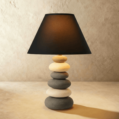Residence Supply Rocky table lamp with a textured stone-like base and a neutral fabric shade on a wooden surface.
