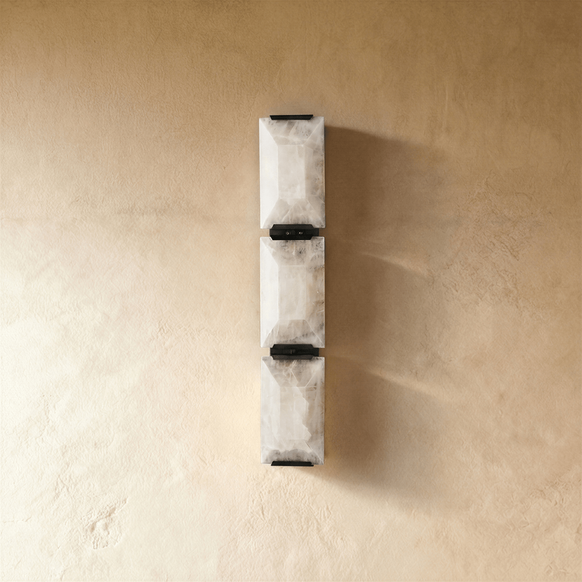 Sakhra wall lamp by Residence Supply featuring a modern, textured ceramic design with warm ambient lighting.