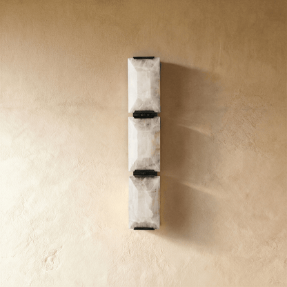 Sakhra wall lamp by Residence Supply featuring a modern, textured ceramic design with warm ambient lighting.