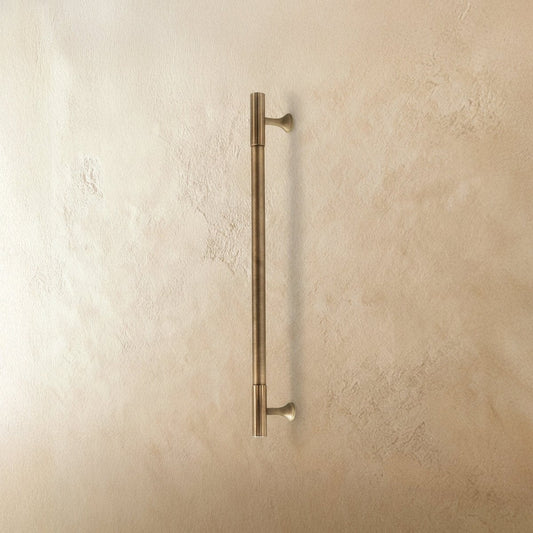 Brass knob and pull bar for cabinets, Residence Supply home hardware, close-up of shiny brass cabinet hardware on a modern kitchen cabinet