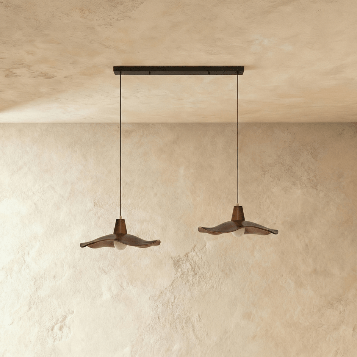 Residence Supply Siraj Pendant Light hanging fixture with a modern design and sleek metal finish, shown in a well-lit interior setting.
