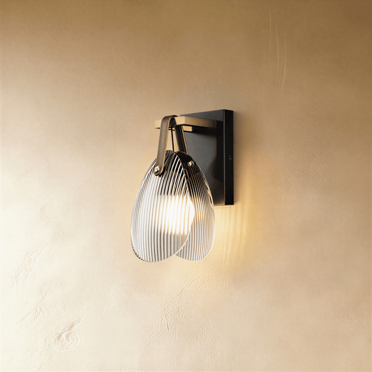 Residence Supply Solya Wall Lamp mounted on a wall with a sleek, modern design and warm lighting.
