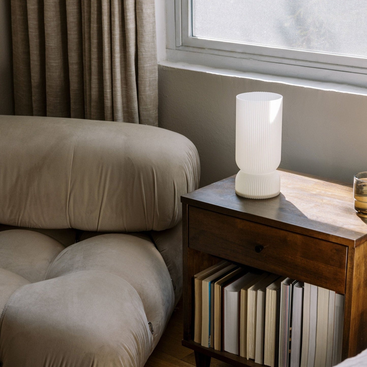 Terra Labs Stance Table Lamp with a sleek, modern design and neutral-colored shade on a wooden surface.