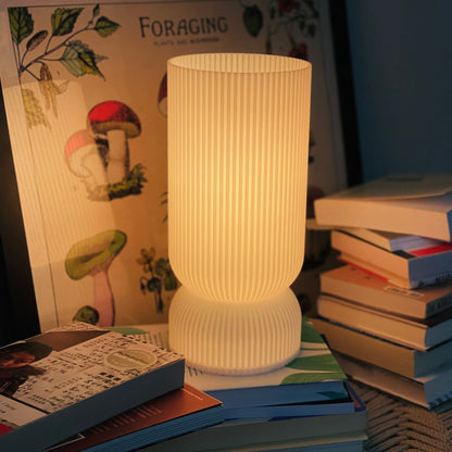 Terra Labs Stance Table Lamp with a sleek modern design, featuring a cylindrical base and a fabric shade on a wooden table.