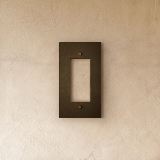 Vintage brass wall plate with aged patina, decorative cover for electrical outlets or switches in home and garden decor.