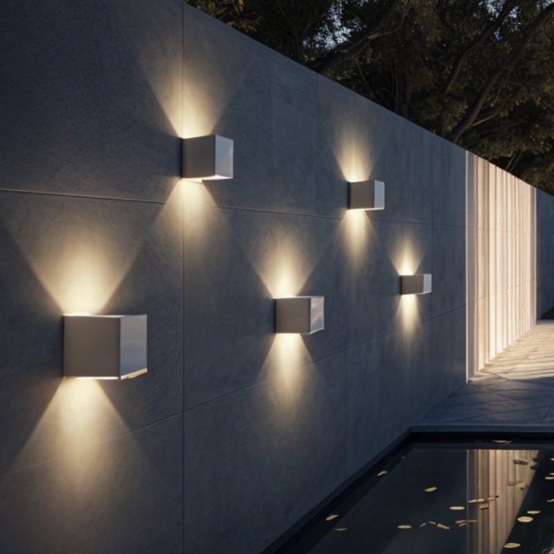 Modern Tine Wall Lamp by Residence Supply featuring sleek metal arm and minimalist design mounted on a wall.