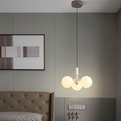 Residence Supply Trilume Pendant Light hanging in a bedroom with a sleek modern design and warm lighting.