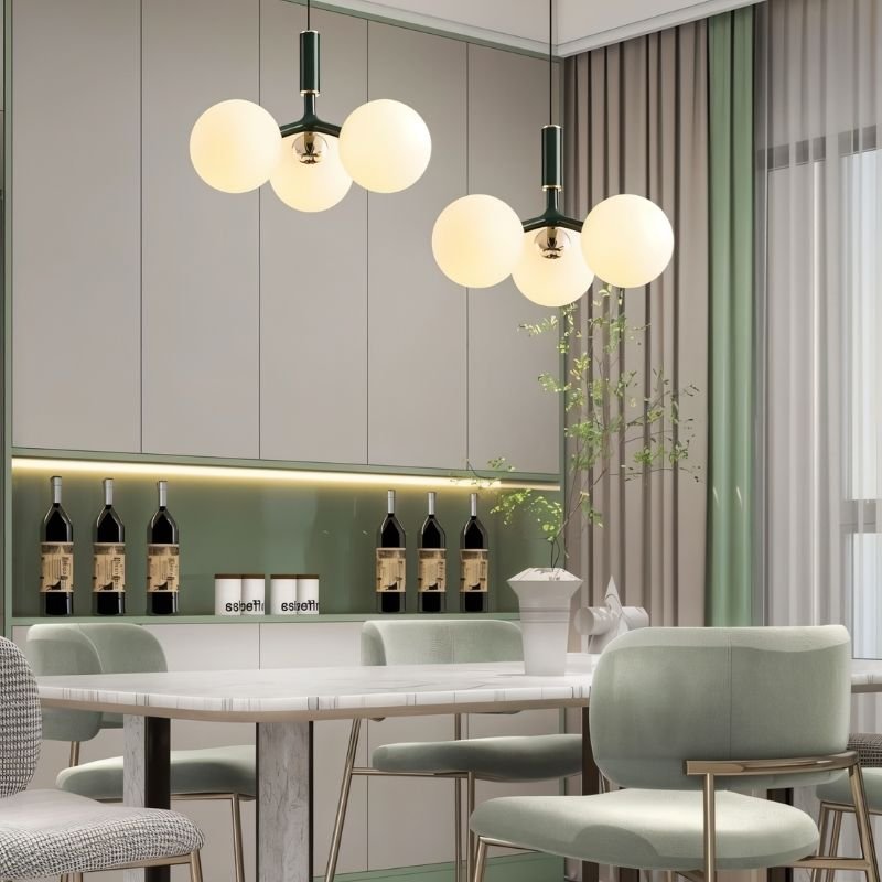 Green Trilume pendant light hanging in a dining room, showcasing its modern design and sleek appearance.