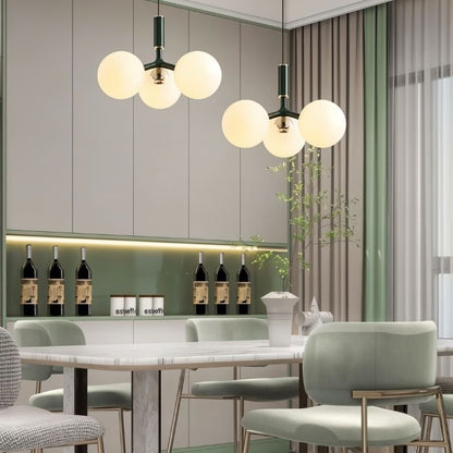 Green Trilume pendant light hanging in a dining room, showcasing its modern design and sleek appearance.