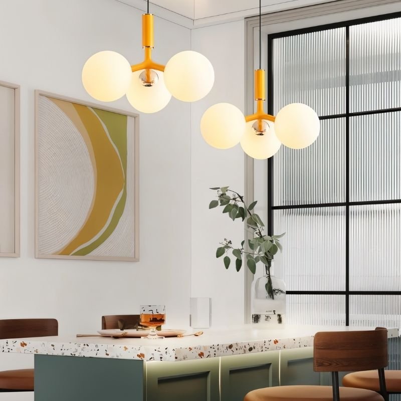Orange Trilume Pendant Light by Residence Supply hanging above a dining table in a modern dining room setting.