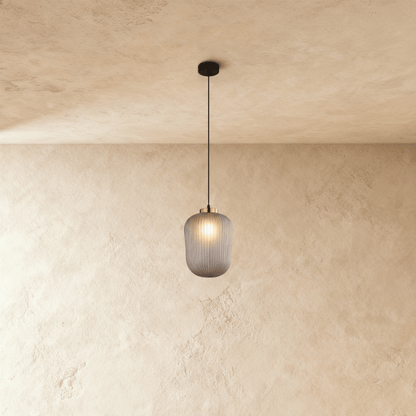 Vahni Pendant Light by Residence Supply hanging from ceiling with a modern design and warm lighting.