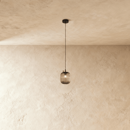 Vahni Pendant Light by Residence Supply hanging from ceiling with a modern design and warm lighting.