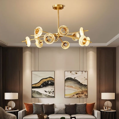 Modern Volrin Chandelier by Residence Supply with glass accents, hanging in a stylish living room setting.