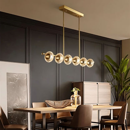 Residence Supply Volrin chandelier with linear glass design hanging above a dining table, modern lighting fixture for dining rooms.